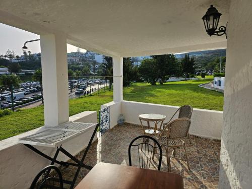 Un porche con sillas y una mesa y una vista de un estacionamiento. en Nassime 1, en Cabo Negro
