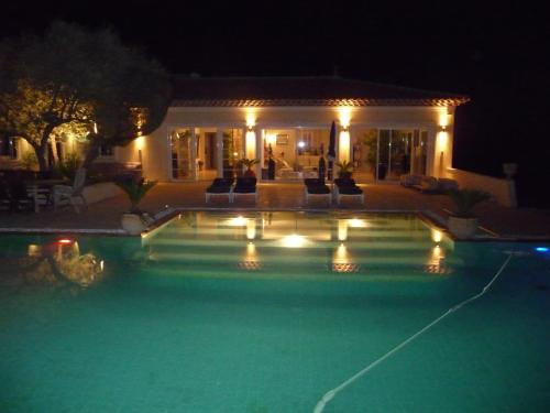 ル・カステレにあるlocation Villa avec piscine chaufféeの夜間の家の前のスイミングプール