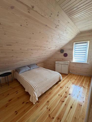 a bedroom with a bed in a wooden room at Sadyba u Gansa in Svityazʼ