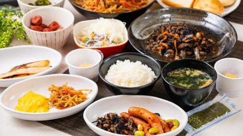 a table topped with bowls of different types of food at Select Inn Numazu in Numazu