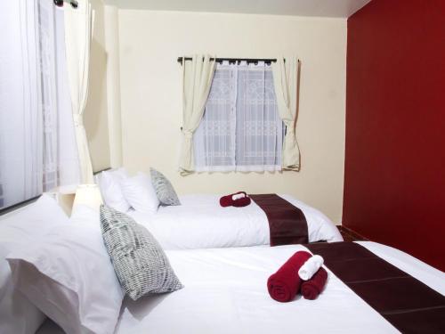 two beds in a bedroom with red towels on them at Cozy House 2BR BTS Ekkamai in Bangkok