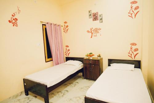 a room with two beds and a dresser at Krishna Kunj Inn in Varanasi
