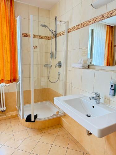 a bathroom with a sink and a shower at Hotel am Hafen Havelberg in Havelberg