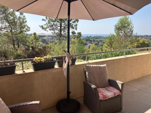 an umbrella on a balcony with a chair and a lamp at BLUE HORIZON T4 3 bedrooms Panoramic sea view in Saint-Raphaël