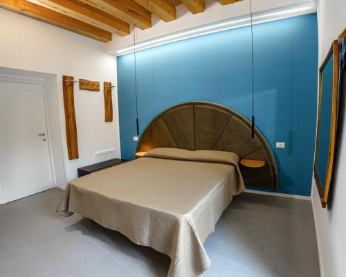 a bedroom with a large bed in a blue wall at Panormos91 Rooms&Terrace in Palermo