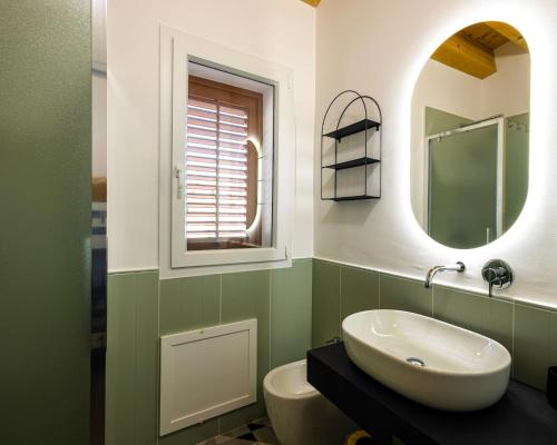 a bathroom with a sink and a mirror and a toilet at Panormos91 Rooms&Terrace in Palermo