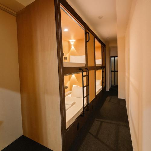 a room with a hallway with a mirror and a bathroom at Wink at Perak Road in Singapore