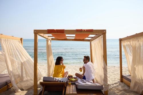 a man and a woman sitting on the beach at Creta Maris Resort in Hersonissos