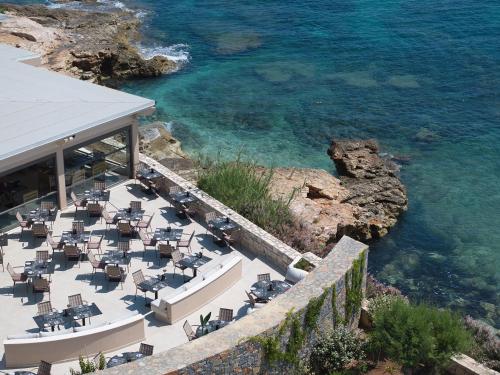 a restaurant with tables and chairs next to the water at Creta Maris Resort in Hersonissos