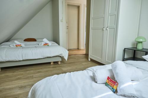 a bedroom with two beds with white sheets at HD Central Topfloor in Bergen
