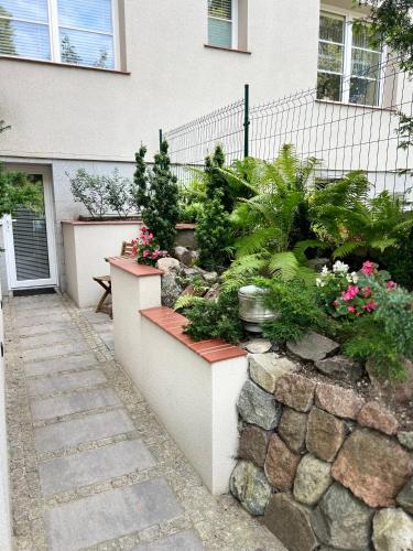 a garden in front of a house with flowers at Costa Apartments in Sopot