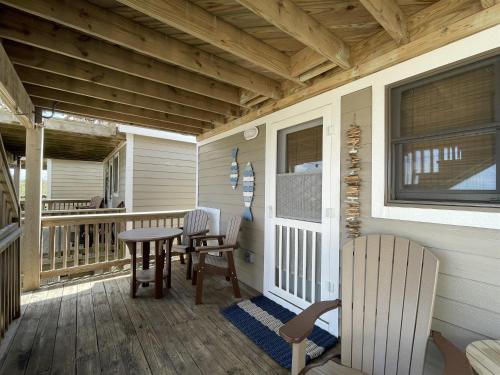 a porch of a house with a table and chairs at 38 Piece Of Heaven Condo in Hatteras