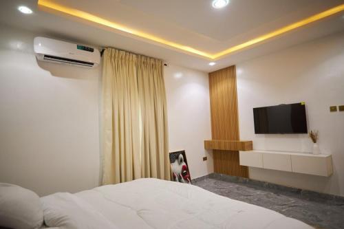 a bedroom with a bed and a flat screen tv at 2 Bed Duplex at Riz Royalty in Sagisa