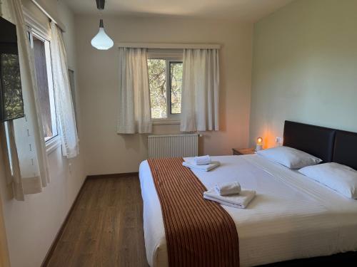 a bedroom with a large bed with two towels on it at Jubilee Hotel Troodos in Troodos