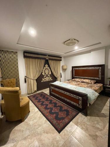 a bedroom with a large bed and a chair at Furnished Apparment Eiffel Tower Bahria town Lahore in Dargai