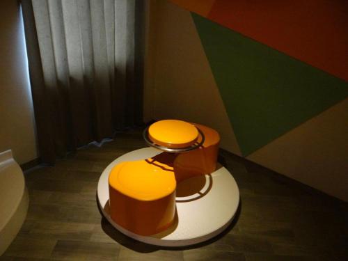 a bathroom with a toilet with a colorful wall at Oh! Oriente Hotel in Mexico City