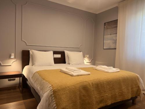 a bedroom with a bed with two towels on it at Fly House Faro in FAO