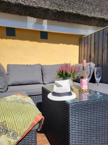 a table with a hat and a bottle of wine at Strandhuset in Agger