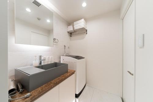 een kleine keuken met een spoelbak en een koelkast bij Brand New Luxury Suite 7 min to Omotesando 2 min to Shibuya in Tokyo