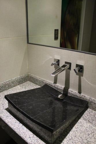 a black sink in a bathroom with a mirror at Oh! Oriente Hotel in Mexico City