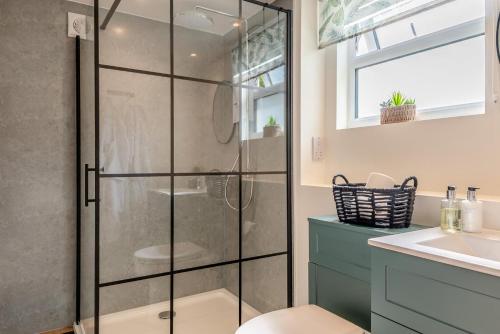 un baño con ducha y lavabo en Bluebell Farm - The Cabin, en Shurdington