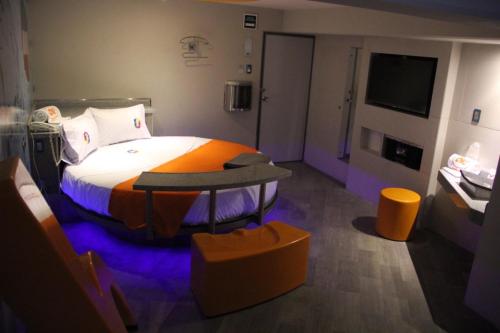 a bedroom with a bed and a table and a tv at Oh! Oriente Hotel in Mexico City
