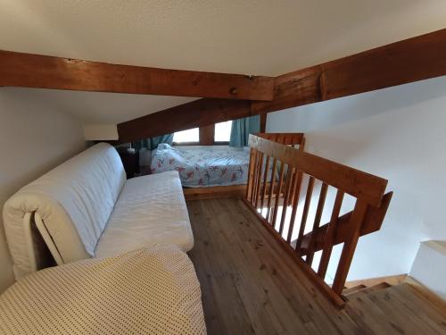 ein Wohnzimmer mit einem Sofa und einer Treppe in der Unterkunft Duplex 4 pers. au calme avec parking, vue imprenable - FR-1-445-227 in Montgenèvre