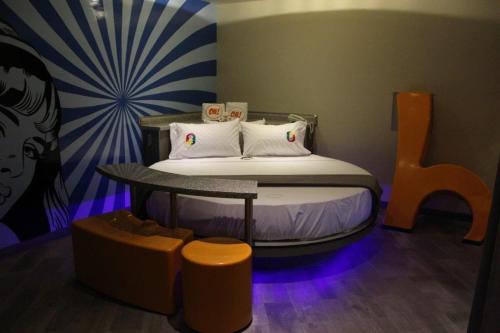a small bedroom with a bed with a table andools at Oh! Oriente Hotel in Mexico City