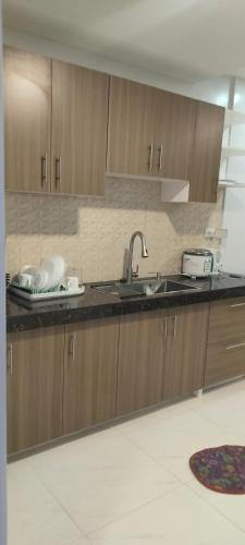 a kitchen with wooden cabinets and a sink at LV Residences Siargao in Dapa