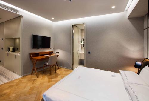 a bedroom with a bed and a desk and a television at Fer Hotel in Istanbul