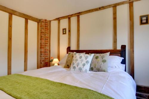 a bed with white sheets and pillows in a room at Wagon Lodge at Forstal Farm in Tenterden