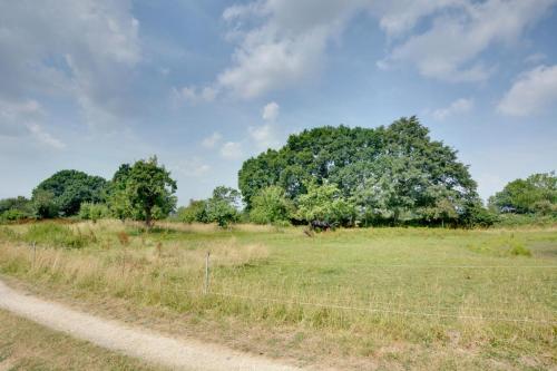 a field with a fence and a tree in the distance at Wagon Lodge at Forstal Farm in Tenterden