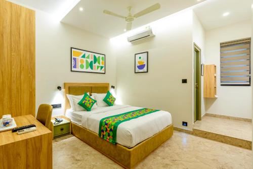 a bedroom with a bed and a desk in a room at Treebo Deluxe Inn, Chromepet in Chennai