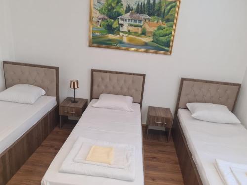 two beds in a room with a painting on the wall at Motel HEKO in Bugojno