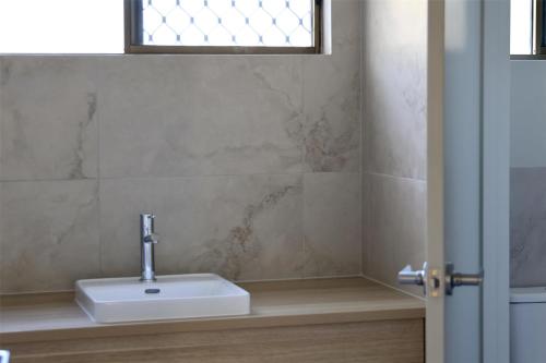 a bathroom with a sink and a window at Nightcap at Kondari Resort in Hervey Bay