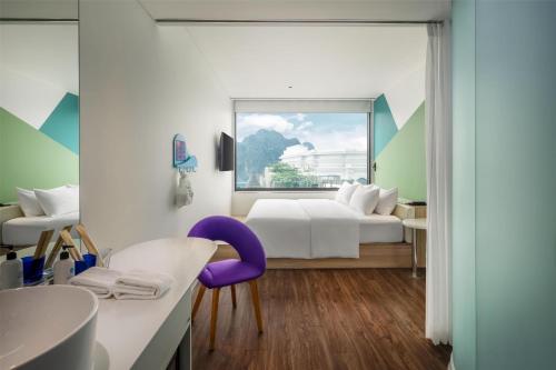 a hotel room with a bed and a bathroom at Tru by Hilton Ha Long Hon Gai Centre in Ha Long