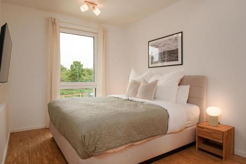 a white bedroom with a bed and a window at Wohnkultur - Ferienhaus für 10 mit Terrasse und Garten in Wiesloch