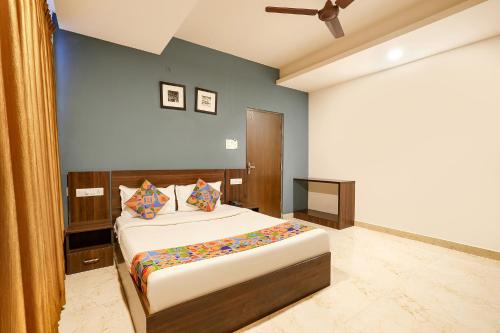 a bedroom with a bed and a ceiling fan at FabHotel Skyline in Bengaluru