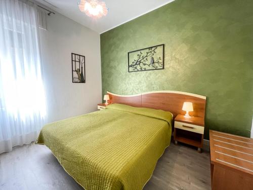 a bedroom with a bed and a green wall at Hotel Alpino in Malcesine