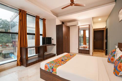 a bedroom with a bed and a large window at FabHotel Skyline in Bengaluru