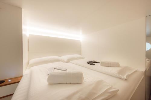 a white bed with two white towels on it at Grand Pods - Capsule Hotel in Vienna