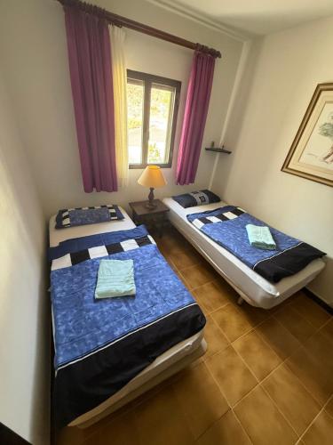 two beds in a room with a window at Giniginamar Atlantic Paradise in Giniginámar
