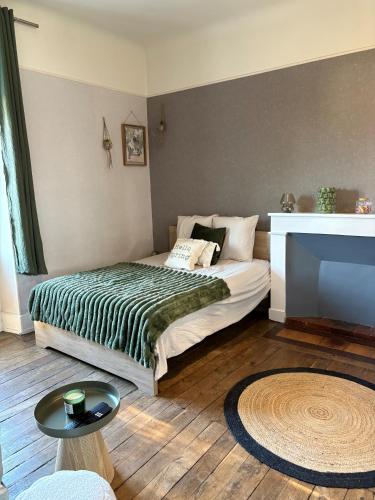 a bedroom with a bed and a table and a television at L'olivier - Futuroscope in Jaunay-Marigny
