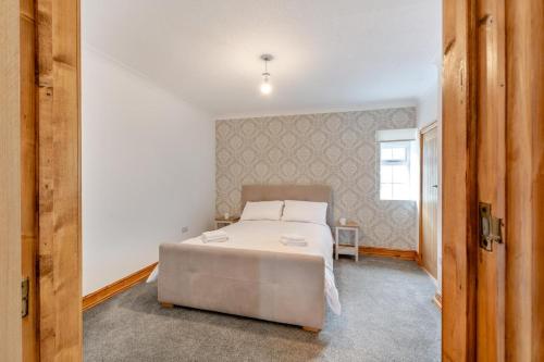 a bedroom with a large white bed and a window at River View at Hanlith Hall in Airton