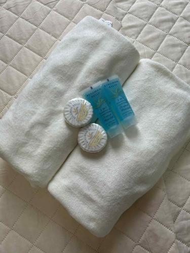 a white blanket with two cups and a package of toothpaste at MyOneSpace4u at One Spatial Condo Hotel in Iloilo City