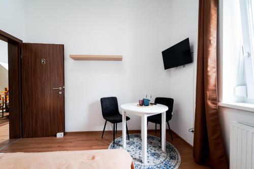 a small white table in a room with two chairs at CitySuites Salzburg in Salzburg