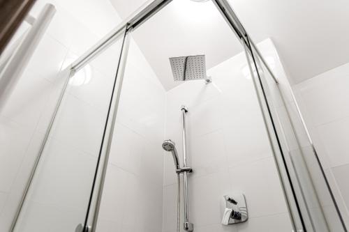 a shower with a glass door in a bathroom at CitySuites Salzburg in Salzburg