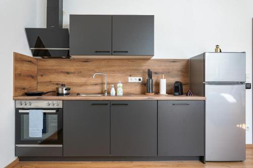 a kitchen with a refrigerator and a sink at CitySuites Salzburg in Salzburg