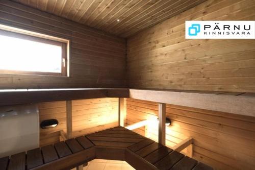 a small room with a small window and wooden walls at Sireli Holiday Home in Pärnu