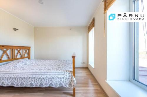 a bedroom with a bed and a large window at Sireli Holiday Home in Pärnu